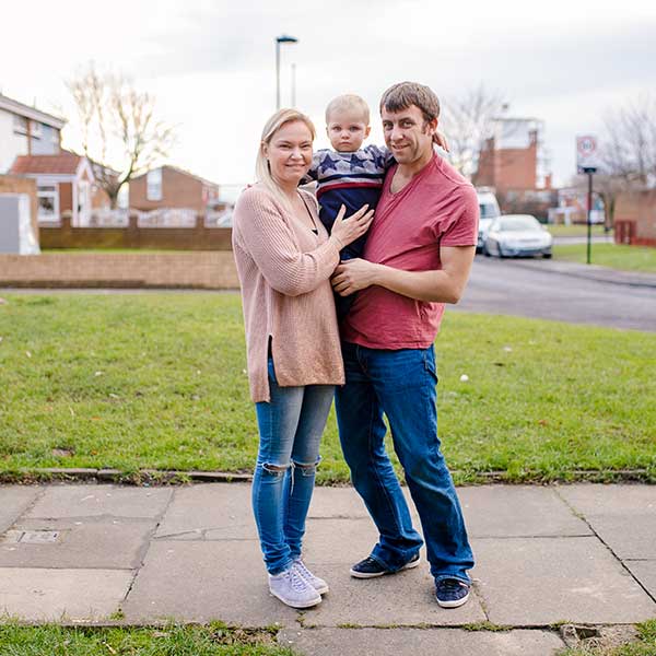 A couple posing with their son