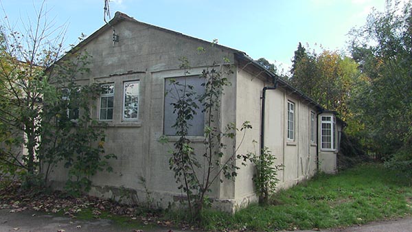 An old and dilapidated building surrounded by weeds on the estate of the epilepsy Society