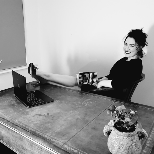 Black and white image of a smiling woman at a desk