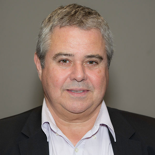 Professor Ley Sander has grey hair and is looking straight at the camera. His mood is serious, rather than smiling. He is wearing a grey jacket and open-necked shirt