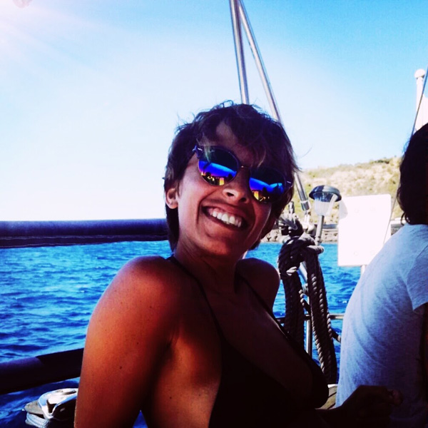 Smiling woman on a boat in the sunshine.