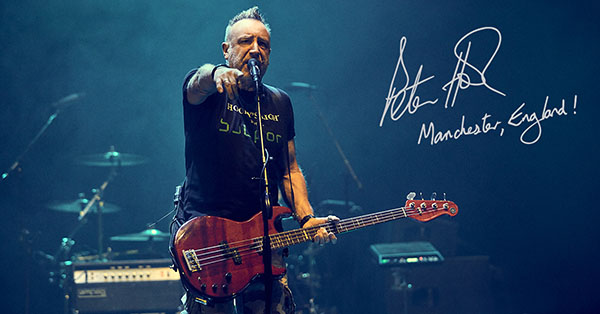 Guitarist Peter Hook is captured on stage, performing on his signature Yamaha guitar