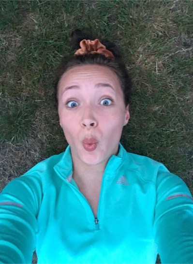 Woman lying on the grass looking into the camera.