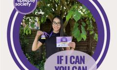 woman holding challenge 100 medal and smiling