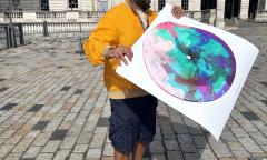 Man standing outside Somerset House holding a print